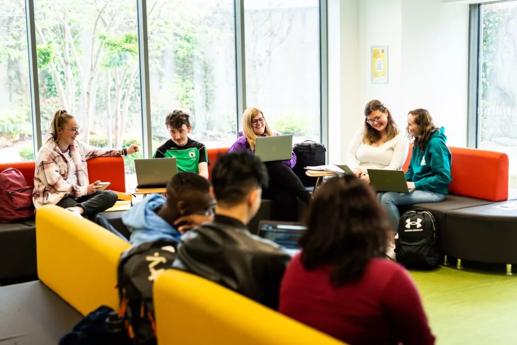 Students working together on laptops in the social space of the Yeats Library