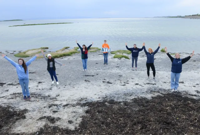 Group of students on beach with an ATU sign