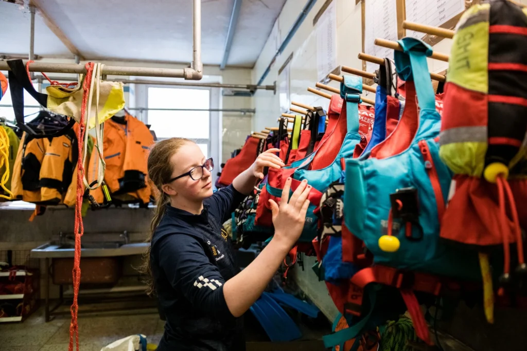 A student is looking through a rack of lifejackets