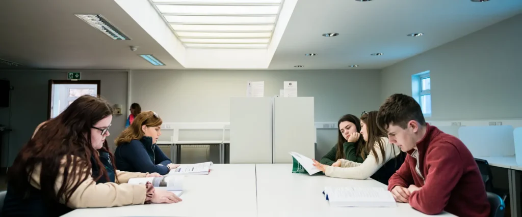 students gathered around a desk in a classroom setting