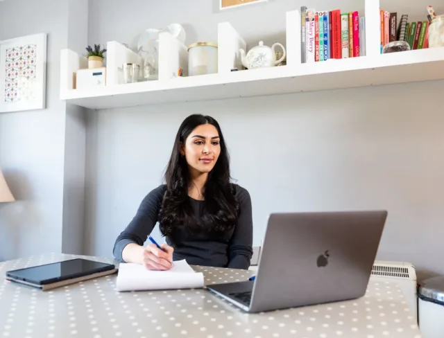 Student taking notes at home