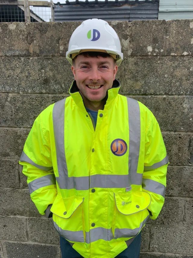 Photo of male student wearing a high-vis jacket and a hard hat