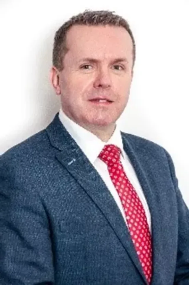 Photo of a male student in a suit with red tie