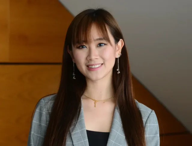 Female international student faces camera wearing grey blazer