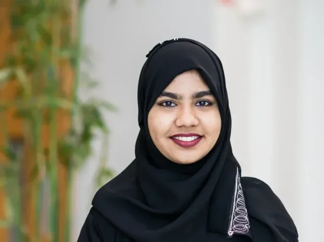 Female international student stand in hallway in black hijab
