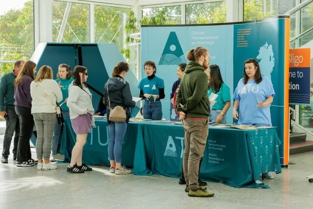 Student Ambassadors greeting new students at the helpdesk in the main foyer
