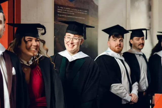 Graduates laughing together at their graduation ceremony
