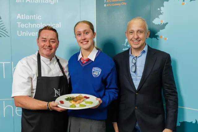 Chef Neven Maguire and student Katie holding her winning salmon dish alongside Derek Gallagher.