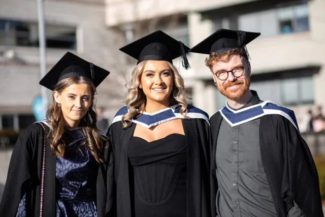 Three students at graduation.