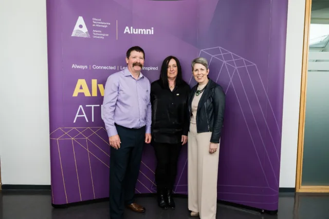 ATU President Dr Orla Flynn pictured with Lauren's parents Michael and Rosie Cadden in front of purple ATU Alumni backdrop