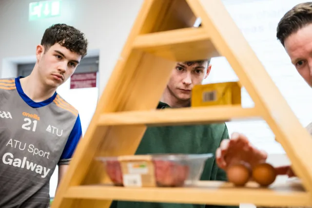 Students standing with model of food pyramid.