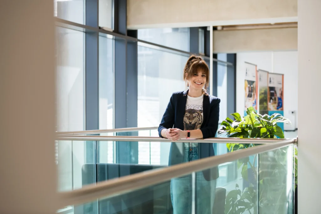 Woman in white t-shirt with a tiger on it and black blazer..