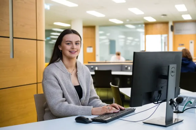 A student is working on a computer in the Sligo campus library