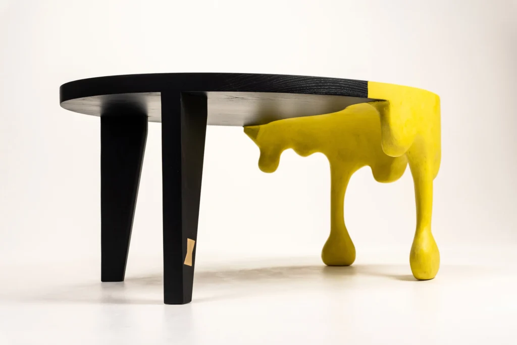 Black and yellow table, the yellow legs appear like a paint drip.
