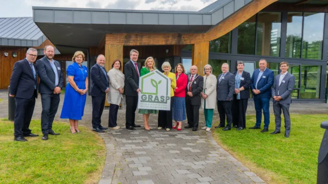 Group shot of stakeholders standing for a photo. The people in the middle of the line holds up a sign that reads GRAPS Green Accelerator Skills Programme