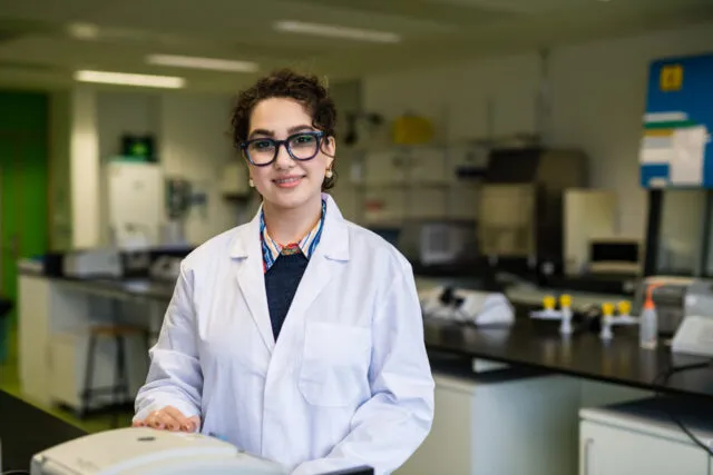 Girl standing in a lab with labcoat
