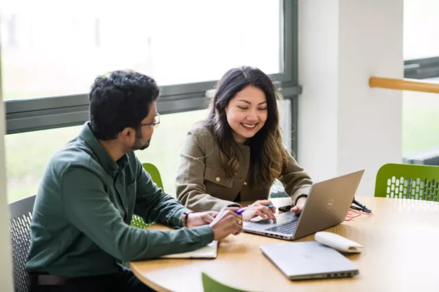 Two researchers looking at a laptop