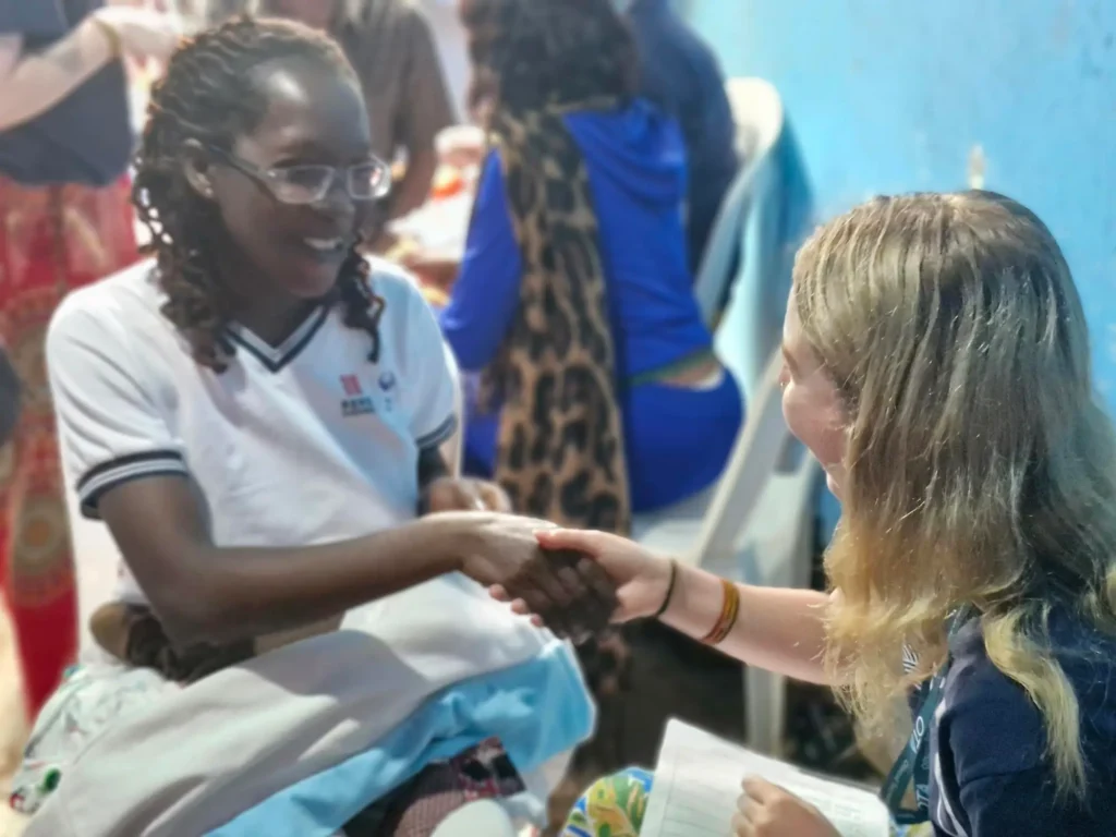Two women shake hands.