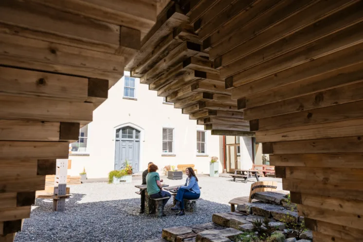 Students at ATU campus at Connemara framed by a wooden structure.