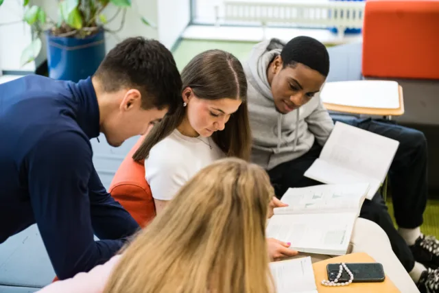 Students reading together at a desk.