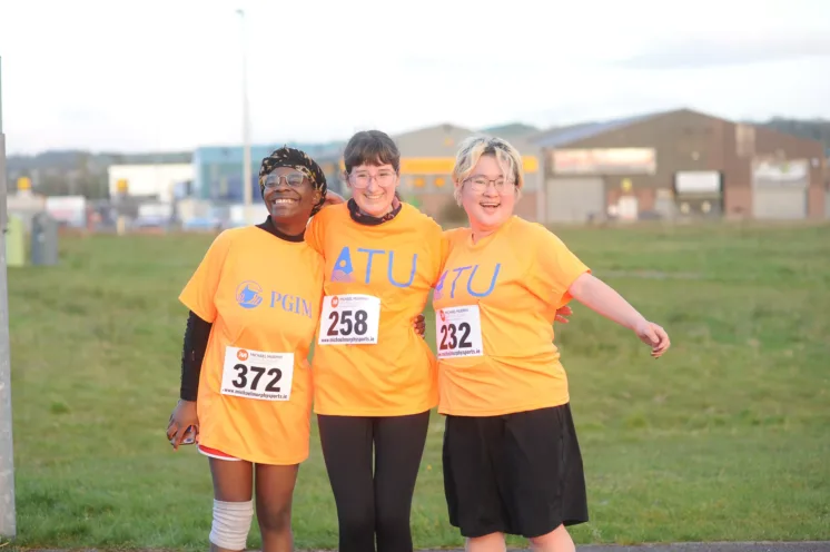 Three people at the ATU Annual Charity 5k in orange ATU T-shirts.