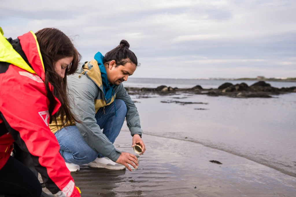 researchers picking up samples at sea