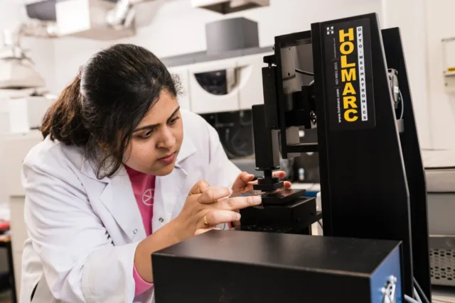Female researcher touching lab equipment