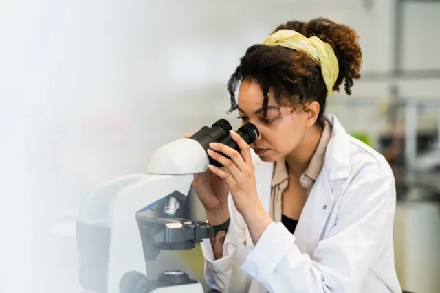 Researcher looking at microscope