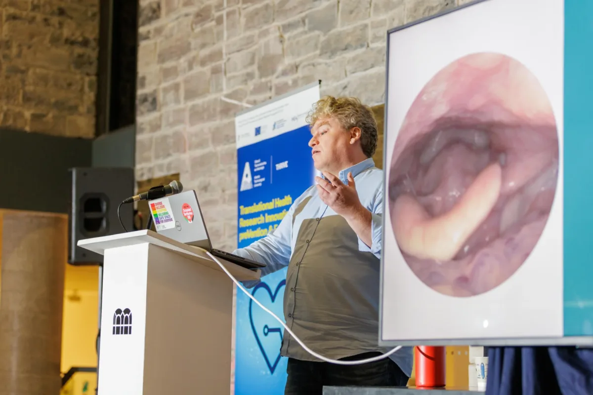 Dr Jamie Roche delivers a presentation with image showing throat