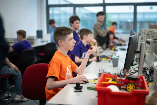 children looking at toys and computers