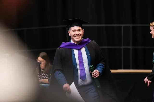 Graduate accepting his postgraduate award at conferring 2026
