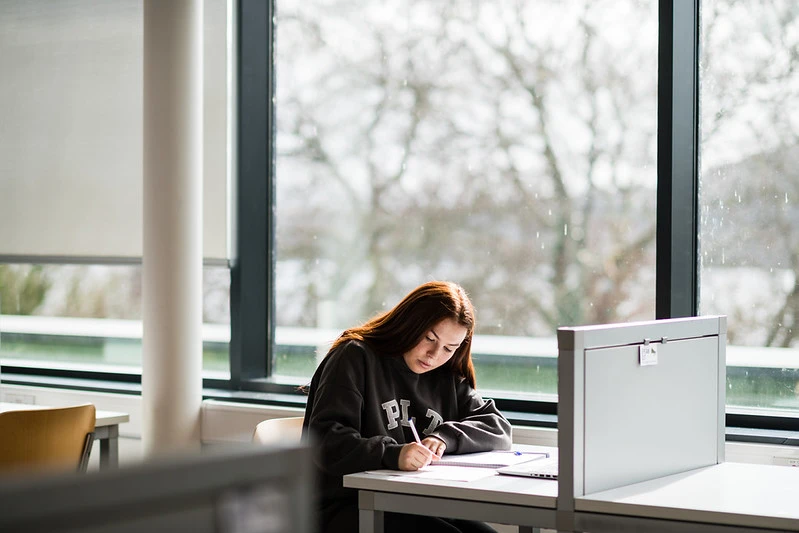 Female student studying at desk in library at St Angelas campus