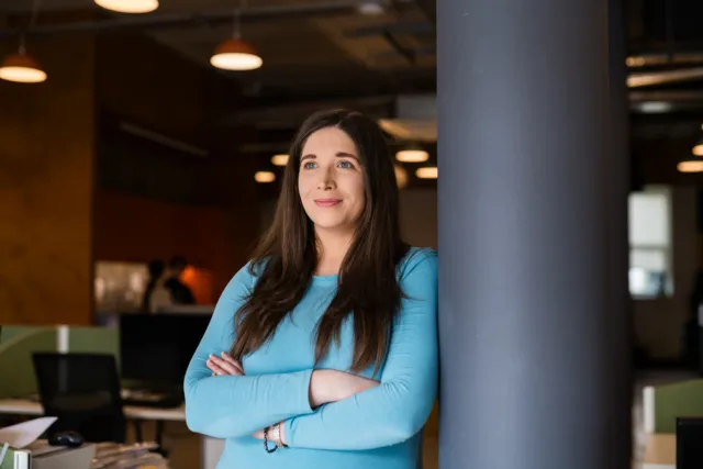Female mature student poses in blue jumper with arms crossed