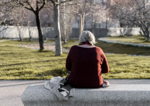 Older person sitting in woods