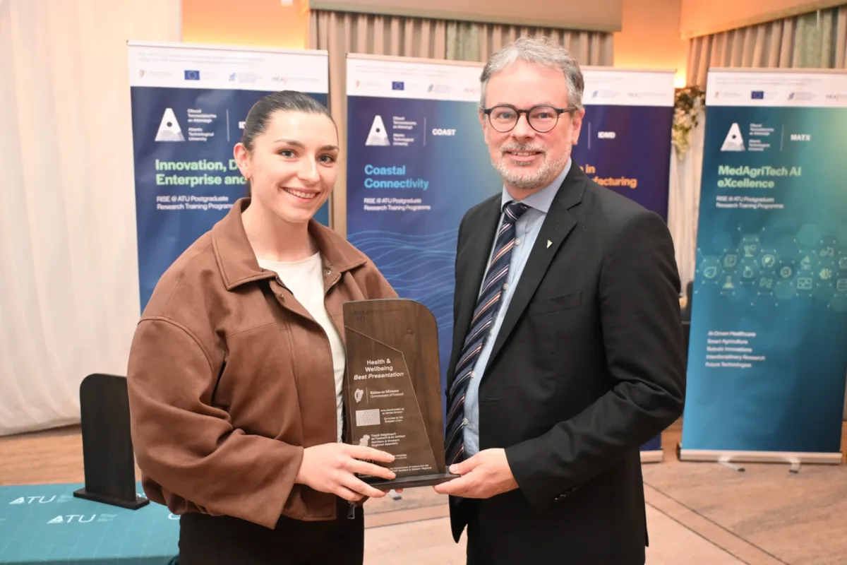 Female student Lauren Callaghan receiving award from CEO of Research, Innovation, and Engagement