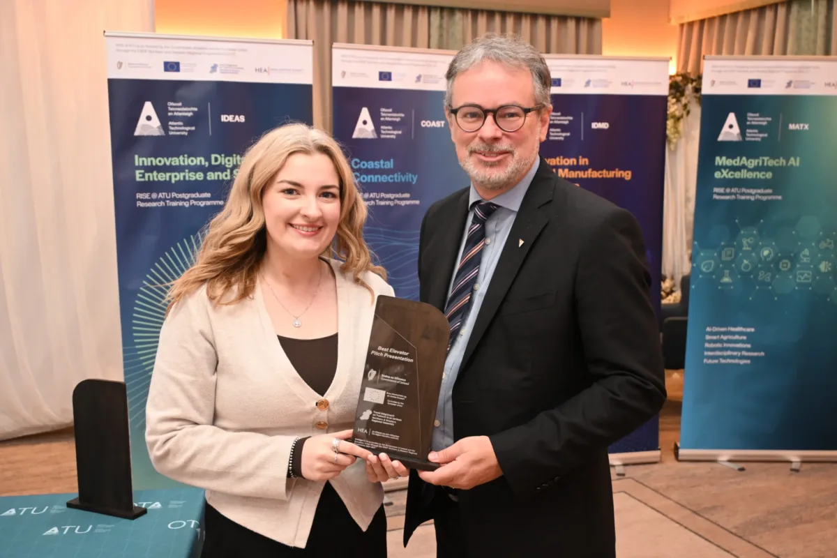 Female student Rebecca Tarpey receiving award from CEO of Research, Innovation, and Engagement