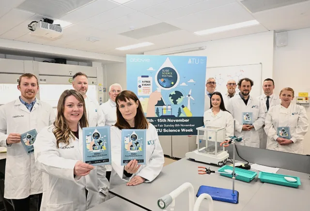 Photograph shows scientists in white laboratory coats presenting ATU Science Week materials inside a teaching laboratory.