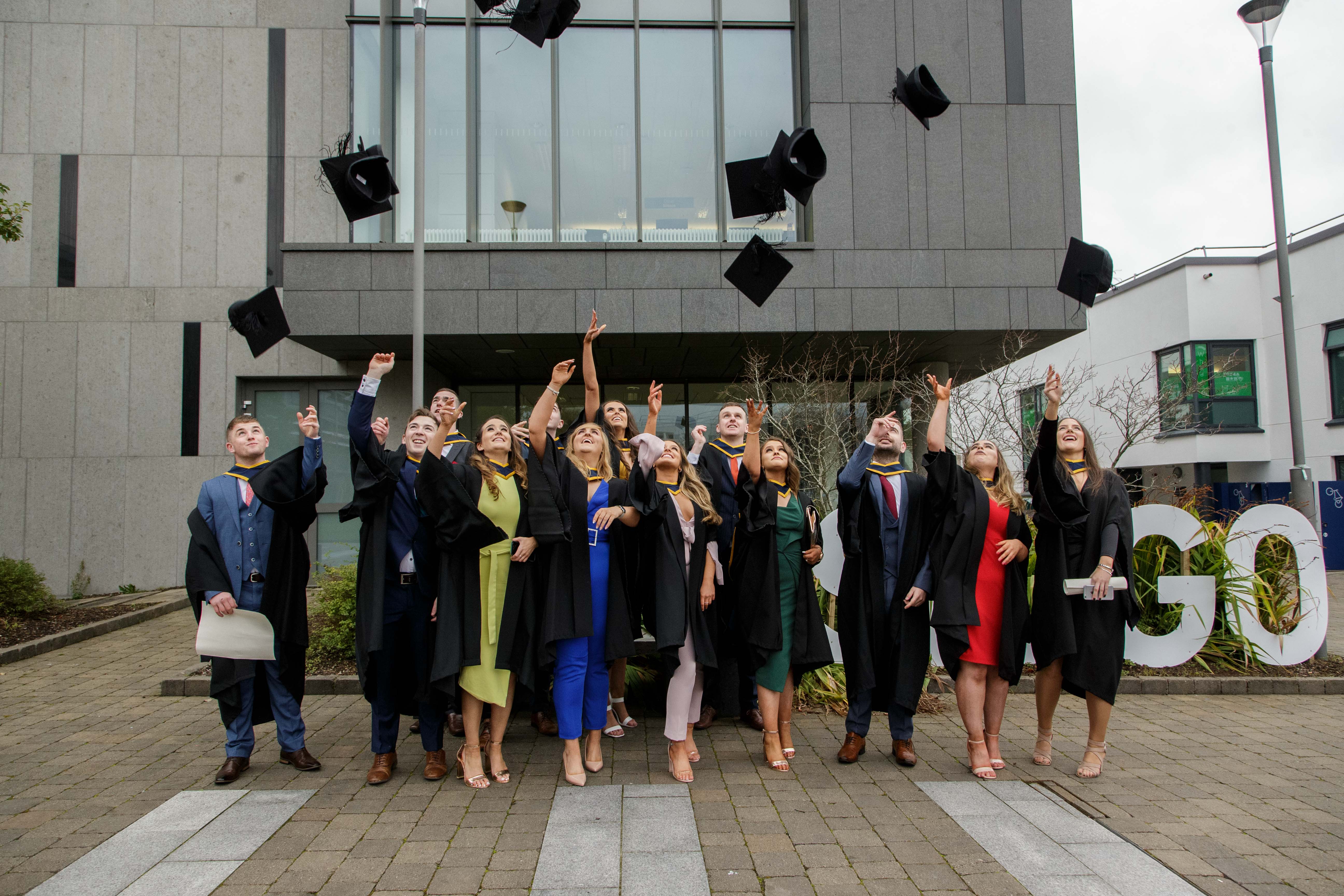 Students graduating from ATU Sligo campus throwing their graduation caps in the air