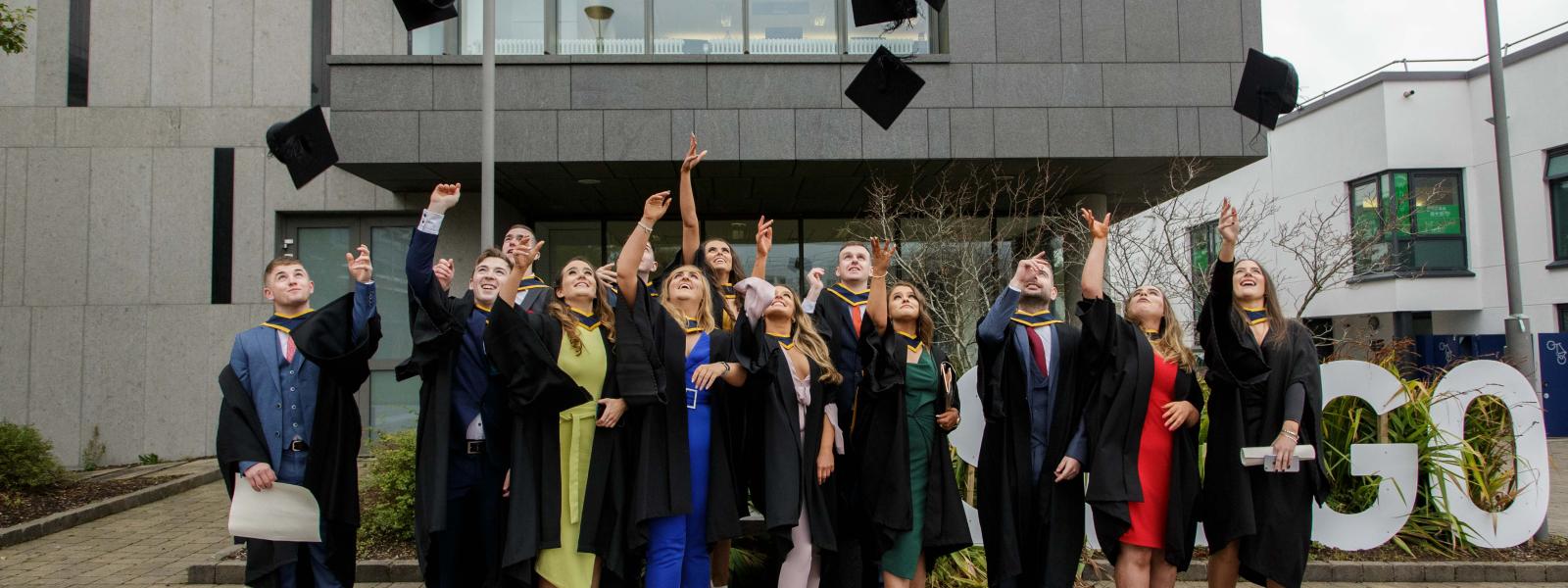 Students graduating from ATU Sligo campus throwing their graduation caps in the air