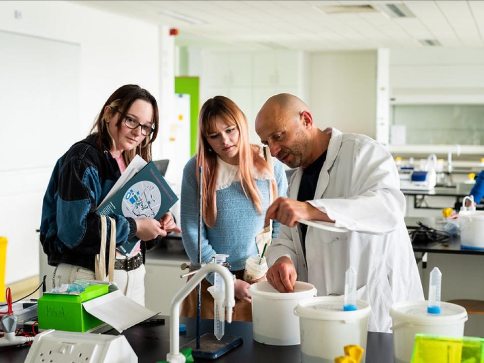 image of lecturer demonstrating an experiment to two students in a Science lab